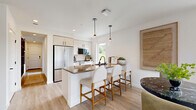 Located in Woodinville, WA, this thoughtfully designed 1-bedroom, 1-bathroom residence offers a well-appointed single-floor layout that maximizes both function and style. Light wood-look flooring flows throughout, complementing a bright, neutral palette.

The open-concept kitchen is a standout, featuring light wood cabinetry with matte black hardware, warm stone countertops, stainless steel appliances, and a peninsula with bar seating—all illuminated by modern pendant lighting and a window overlooking greenery. It connects seamlessly to the living room, which is bathed in natural light from large windows and a glass door opening to a balcony with panoramic views of the Woodinville landscape.

The bedroom is a serene retreat with oversized windows, a ceiling fan, and views of the surrounding neighborhood and treeline. The full bathroom offers a soaking tub with tile surround, light wood vanity, warm stone countertops, and a large mirror with contemporary black fixtures.

A dedicated office space, painted in a calming sage green, features built-in floating shelves and generous natural light—ideal for remote work. Two closets and a hallway round out this efficiently planned residence, delivering comfort, style, and functionality in one cohesive package.