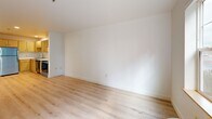 Located at 1323 SW Cherry Park Rd in Troutdale, Oregon, this one-bedroom, one-bathroom unit offers a thoughtfully designed single-floor layout that maximizes every square foot of its compact footprint. Light hardwood flooring flows consistently throughout the living areas, creating a cohesive and bright aesthetic complemented by crisp white walls and clean finishes.

The open living, dining, and kitchen area forms the heart of the space. Large windows invite generous natural light and frame views of the surrounding greenery, giving the living area an open and airy feel. The kitchen is well-equipped with light maple cabinetry offering ample storage, white countertops, a stainless steel refrigerator, electric range, dishwasher, and a modern sink with a pull-down faucet.

The bedroom features its own large window overlooking lush outdoor scenery, a wall unit for climate control, and a double closet with classic paneled doors providing practical storage. A second closet adds additional storage flexibility to the unit.

The bathroom is finished with neutral tile flooring, a glass-enclosed shower stall, a vanity with a countertop sink, and a toilet — all neatly arranged for efficient use of space. A private patio rounds out this unit, offering a dedicated outdoor retreat.