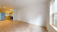 Located at 1323 SW Cherry Park Rd in Troutdale, Oregon, this one-bedroom, one-bathroom unit offers a thoughtfully designed single-floor layout that maximizes every square foot of its compact footprint. Light hardwood flooring flows consistently throughout the living areas, creating a cohesive and bright aesthetic complemented by crisp white walls and clean finishes.

The open living, dining, and kitchen area forms the heart of the space. Large windows invite generous natural light and frame views of the surrounding greenery, giving the living area an open and airy feel. The kitchen is well-equipped with light maple cabinetry offering ample storage, white countertops, a stainless steel refrigerator, electric range, dishwasher, and a modern sink with a pull-down faucet.

The bedroom features its own large window overlooking lush outdoor scenery, a wall unit for climate control, and a double closet with classic paneled doors providing practical storage. A second closet adds additional storage flexibility to the unit.

The bathroom is finished with neutral tile flooring, a glass-enclosed shower stall, a vanity with a countertop sink, and a toilet — all neatly arranged for efficient use of space. A private patio rounds out this unit, offering a dedicated outdoor retreat.