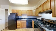 Located at 38 N Summit Dr in Gaithersburg, MD, this single-floor, three-bedroom home offers a practical and comfortable layout. The living area is generously sized, featuring soft wall-to-wall carpeting, crown molding, and a sliding glass door that opens to an outdoor balcony, bringing in natural light and outdoor views. The kitchen is well-equipped with warm oak cabinetry, dark granite countertops, black appliances including a refrigerator, dishwasher, and electric range, and tile flooring. A breakfast bar peninsula connects the kitchen to a bright dining nook complete with a ceiling fan and a large window overlooking the exterior. The spacious primary bedroom offers ample room and connects to a dedicated closet area with double bifold doors providing generous storage. The additional bedrooms are carpeted and well-lit, each featuring large windows with outdoor views and clean, neutral finishes. The full bathroom is distinctively finished with classic light-blue tile surrounding the tub and shower area, complemented by white mosaic floor tile and a vanity with wood cabinetry. Crown molding and consistent neutral tones throughout the home contribute to a cohesive, tidy ambiance.
