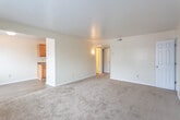 Located at 537 Bellwood Rd in Newport News, Virginia, this single-floor unit offers a practical and comfortable layout designed for everyday living. The interior is finished with neutral cream-toned walls throughout, creating a bright and cohesive aesthetic across all rooms.

The living area is generously sized, featuring plush wall-to-wall carpeting and a window that allows natural light to fill the space. It connects seamlessly to the kitchen and dining area, which transitions to durable wood-style vinyl flooring. The kitchen is equipped with warm honey-toned wood cabinetry, dark granite-style countertops, a double basin sink, and a coil-top electric range, providing all the essentials for meal preparation.

The unit includes multiple bedrooms, each finished with soft carpeting, ample wall space, and individual closets with rod storage for organization. One bedroom features a wall-mounted air conditioning unit, while another benefits from two closets, including a walk-in style, offering exceptional storage capacity. Each room is served by windows fitted with horizontal blinds for privacy and light control.

The bathroom is well-appointed with a full soaking tub and shower surround featuring built-in shelving, a toilet, and wood-style flooring, giving the space a clean and functional finish. Clean white trim and baseboards run throughout, adding a polished touch to the overall interior.