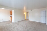 Located at 537 Bellwood Rd in Newport News, Virginia, this single-floor unit offers a practical and comfortable layout designed for everyday living. The interior is finished with neutral cream-toned walls throughout, creating a bright and cohesive aesthetic across all rooms.

The living area is generously sized, featuring plush wall-to-wall carpeting and a window that allows natural light to fill the space. It connects seamlessly to the kitchen and dining area, which transitions to durable wood-style vinyl flooring. The kitchen is equipped with warm honey-toned wood cabinetry, dark granite-style countertops, a double basin sink, and a coil-top electric range, providing all the essentials for meal preparation.

The unit includes multiple bedrooms, each finished with soft carpeting, ample wall space, and individual closets with rod storage for organization. One bedroom features a wall-mounted air conditioning unit, while another benefits from two closets, including a walk-in style, offering exceptional storage capacity. Each room is served by windows fitted with horizontal blinds for privacy and light control.

The bathroom is well-appointed with a full soaking tub and shower surround featuring built-in shelving, a toilet, and wood-style flooring, giving the space a clean and functional finish. Clean white trim and baseboards run throughout, adding a polished touch to the overall interior.