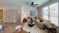 This single-floor residence offers a thoughtfully designed layout that balances comfort and modern style throughout. The open living area serves as the heart of the home, featuring wood-look flooring, a ceiling fan, and large windows dressed with blinds that invite natural light. A sliding glass door leads to a private balcony, extending the living space outdoors. The kitchen is outfitted with white shaker-style cabinetry, granite countertops, a subway tile backsplash, and a full suite of stainless steel appliances including a refrigerator with ice maker, electric range, and over-the-range microwave. Track lighting overhead ensures a bright, functional workspace. The primary bedroom is generously sized with ceiling fan, plush carpeting, and a spacious en-suite bathroom featuring a wide double-sink vanity with granite countertops, wood-look tile flooring, and a soaking tub with shower. A second well-proportioned bedroom also features a ceiling fan and ample natural light. The secondary bathroom mirrors the refined finishes found throughout, complete with a tub-shower combination and wood-look flooring. Neutral tones and clean lines create a cohesive, welcoming ambiance across every room in this move-in-ready residence.