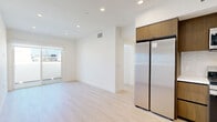 Located at 1343 Tamarind Ave in the heart of Hollywood, Los Angeles, this well-appointed unit offers 7 bedrooms and 4 bathrooms across a thoughtfully designed single-floor layout. Light wood flooring flows consistently throughout the space, complementing the clean white walls and recessed lighting that give every room a bright, contemporary feel.

The kitchen is outfitted with warm wood cabinetry, white quartz countertops, a tile backsplash, and a full suite of stainless steel appliances including a gas range, microwave, dishwasher, and full-size refrigerator. A dedicated in-unit stacked washer and dryer adds everyday convenience.

The seven bedrooms are generously designed, each featuring large windows that invite abundant natural light and offer views of the surrounding Hollywood neighborhood, with palm trees visible from several rooms. Select bedrooms include mirrored sliding closets or direct access to a private outdoor balcony via sliding glass doors. The primary bedroom provides a comfortable retreat with a mirrored closet and wide cityscape-facing window.

The four bathrooms maintain a consistent modern aesthetic, featuring glass-enclosed walk-in showers with large-format tile surrounds, wood-toned floating vanities with white countertops, and light flooring. The overall ambiance is clean, minimal, and move-in ready.