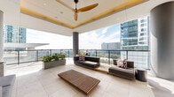 Located in the heart of Houston's downtown district at 808 Crawford St, this sophisticated rooftop lounge seamlessly blends indoor comfort with open-air living. The single-floor space is generously proportioned, offering a fluid layout that transitions effortlessly between an interior lounge and a series of expansive outdoor terrace areas.

Floor-to-ceiling glass walls and sliding glass doors define the interior lounge, flooding the space with abundant natural light while framing sweeping views of the Houston skyline. Coffered ceilings with recessed lighting and statement ceiling fans add architectural character and comfort to the covered areas.

The outdoor terraces are thoughtfully appointed with a variety of seating arrangements, including modular sectional sofas with colorful accent pillows, hanging egg chairs, slatted wood benches, and alfresco dining tables with woven rope chairs — catering to both relaxed lounging and social gatherings. Large planter boxes filled with lush greenery are strategically placed throughout, softening the urban aesthetic.

Large-format porcelain tile flooring extends continuously from the interior through the outdoor zones, reinforcing the cohesive design. Glass railings along the perimeter ensure unobstructed panoramic views of Houston's iconic skyline, making this rooftop an exceptional urban retreat.