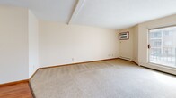 Located at 911 6th Ave NE in Buffalo, Minnesota, this two-bedroom, one-bathroom unit offers a practical and functional single-floor layout. The open-concept living, dining, and kitchen area serves as the heart of the home, with warm hardwood-style flooring underfoot and a ceiling fan overhead. The kitchen is well-equipped with white cabinetry accented by wood trim, a full suite of white appliances including a refrigerator, range, and dishwasher, a stainless steel sink, and ample counter space — all illuminated by under-cabinet lighting.

The primary bedroom is a generous size, featuring plush carpeting and a sliding glass door that opens to an outdoor balcony, allowing for natural light and exterior views. The second bedroom also features carpeting and a window overlooking the surrounding community. Both bedrooms benefit from good natural light and neutral wall tones. Throughout the unit, four closets provide exceptional storage capacity, including a spacious walk-in style closet with a full-length hanging rod and shelf.

The full bathroom includes a soaking tub with shower, wood-toned vanity cabinetry, and hardwood-style flooring. A hallway connects the main living spaces to the bedrooms and bathroom, creating a clean and organized flow throughout this well-maintained unit.