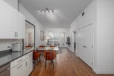 This well-appointed 2-bedroom, 2-bathroom residence at 417 Centinela Ave in Inglewood, California offers a thoughtfully designed single-level layout. Warm hardwood flooring runs throughout, unifying the open-concept kitchen and living area at the heart of the home. The kitchen is outfitted with white shaker cabinetry, gray countertops, stainless steel appliances including a refrigerator, range, microwave, and dishwasher, providing ample storage and a clean, modern aesthetic. The living and dining area flows naturally from the kitchen, benefiting from large windows with greenery views and direct access to a private patio, allowing natural light to fill the space. The primary bedroom is a comfortable retreat with a sliding closet and soft neutral tones. The second bedroom also features a sliding closet and a window with garden views, making it equally versatile. Both bathrooms mirror the home's clean design language, featuring white cabinetry, gray countertops, and tub-shower combinations with hardwood flooring. Additional conveniences include a dedicated laundry area and two closets. The overall ambiance is modern and bright, with a cohesive neutral palette throughout.