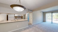 Located at 1009 Lismore Ln in Indianapolis, Indiana, this single-floor residence offers four bedrooms and three bathrooms within a efficiently arranged layout. The combined kitchen and living room serves as the heart of the home, where a peninsula-style kitchen features granite countertops, a stainless steel sink, white cabinetry with modern hardware, and white appliances including a refrigerator, range, and built-in microwave. The living area is finished with plush carpeting and a sliding glass door that fills the space with natural light and provides direct access to an outdoor area. Each of the four bedrooms is carpeted and neutral in tone, with textured ceilings and windows that bring in natural light and views of surrounding greenery. The primary bedroom offers generous proportions and includes closet space. The three bathrooms are appointed with granite-topped vanities, white cabinetry, and wood-look flooring. At least one bathroom features a tub/shower combination with full-height tile surround in a neutral stone-like finish. Throughout the residence, a consistent neutral color palette and clean finishes create a bright, cohesive atmosphere well-suited for comfortable everyday living.