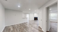 Located at 1235 Ashbourne Rd in Elkins Park, PA, this two-bedroom, two-bathroom residence spans two floors and offers a clean, modern aesthetic throughout. The open-concept living room serves as the heart of the home, anchored by a sleek fireplace with a classic white surround and finished with light-toned hardwood flooring. Recessed lighting illuminates the space, while sliding glass doors lead to a private balcony overlooking a lush, tree-lined neighborhood streetscape. The kitchen is thoughtfully designed with two-tone cabinetry—white upper cabinets paired with dark lower units—complemented by quartz countertops, a tile backsplash, and a full suite of stainless steel appliances. Both bedrooms feature plush carpeting and recessed lighting, with the primary bedroom offering a dedicated closet. The bathrooms are finished with tile flooring and full tub-shower combinations accented by decorative mosaic tile detailing. A dedicated laundry room houses a full-size washer and dryer with built-in wire shelving for additional storage. Two closets round out the practical storage options throughout this well-appointed residence.