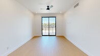 This modern 3-bedroom, 1-bathroom unit in Phoenix, AZ offers a thoughtfully designed single-floor layout with clean, contemporary finishes throughout. Light wood flooring runs continuously across all rooms, creating a warm and cohesive aesthetic against the crisp white walls and ceilings.

The kitchen is a standout feature, showcasing flat-front wood-tone cabinetry, a decorative stone tile backsplash, stainless steel appliances, and a spacious white quartz island with an undermount sink. Stylish pendant lighting adds a modern accent overhead.

The primary bedroom is generously sized and features a ceiling fan, recessed lighting, and sliding glass doors that open to a balcony with views of the Phoenix skyline and surrounding mountains. The additional bedrooms are bright and well-proportioned, each with large black-framed windows that bring in abundant natural light and views of the neighborhood.

The bathroom is clean and contemporary, featuring a glass-enclosed walk-in shower with marble-style tile surrounds, a single vanity, and warm wood flooring. A dedicated laundry area with a water heater provides added convenience.

A hallway connects the bedrooms and bathroom efficiently, completing the functional and modern layout of this well-appointed Phoenix residence.