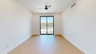 This modern 3-bedroom, 1-bathroom unit in Phoenix, AZ offers a thoughtfully designed single-floor layout with clean, contemporary finishes throughout. Light wood flooring runs continuously across all rooms, creating a warm and cohesive aesthetic against the crisp white walls and ceilings.

The kitchen is a standout feature, showcasing flat-front wood-tone cabinetry, a decorative stone tile backsplash, stainless steel appliances, and a spacious white quartz island with an undermount sink. Stylish pendant lighting adds a modern accent overhead.

The primary bedroom is generously sized and features a ceiling fan, recessed lighting, and sliding glass doors that open to a balcony with views of the Phoenix skyline and surrounding mountains. The additional bedrooms are bright and well-proportioned, each with large black-framed windows that bring in abundant natural light and views of the neighborhood.

The bathroom is clean and contemporary, featuring a glass-enclosed walk-in shower with marble-style tile surrounds, a single vanity, and warm wood flooring. A dedicated laundry area with a water heater provides added convenience.

A hallway connects the bedrooms and bathroom efficiently, completing the functional and modern layout of this well-appointed Phoenix residence.