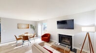 Located in Dover, Delaware, this well-appointed 2-bedroom, 3-bathroom single-floor residence offers a thoughtfully designed layout with a clean, modern aesthetic throughout. Light wood-tone flooring runs throughout the space, contributing to a bright and cohesive feel.

The combined living and dining area serves as the heart of the home, anchored by a classic fireplace with a white mantle and a wall-mounted flat-screen TV. Natural light filters through sliding glass doors that overlook an outdoor area, while the open layout allows the dining space to flow seamlessly alongside the living room.

The kitchen features white shaker-style cabinetry with brushed nickel hardware, dark countertops, and black appliances including a range and refrigerator, all set against light wood flooring.

The primary bedroom is a spacious retreat with a natural light source via a window and ample room to accommodate generous furnishings. Additional bedrooms are well-proportioned with natural light. Four closets throughout the unit provide excellent storage capacity.

Three full bathrooms include tiled tub-shower combinations with clean, white finishes and vanity mirrors. A dedicated laundry room and a utility room add further practicality. The entry hallway features a wood wall-mounted coat rack, offering a welcoming arrival experience.