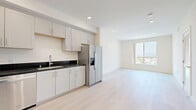 Located at 433 Rosenell Terr in Los Angeles, CA 90026, this thoughtfully designed 3-bedroom, 2-bathroom unit offers a clean, modern aesthetic throughout its single-floor layout. The kitchen is a standout feature, equipped with full stainless steel appliances including a French door refrigerator with ice maker, electric range, dishwasher, and over-the-range microwave. White shaker cabinetry reaches toward the ceiling, complemented by dark granite countertops and a stainless steel sink. Light-toned hardwood flooring flows seamlessly throughout the entire unit, lending a bright and cohesive feel. The open area adjacent to the kitchen benefits from a large window that invites natural light and frames outdoor views of the surrounding Los Angeles neighborhood. The bedrooms are clean and neutral, with recessed lighting and windows providing natural light. The primary bedroom offers a comfortable footprint for furnishing. Both bathrooms maintain the unit's modern palette, featuring white shaker vanities with dark granite countertops. One bathroom includes a full shower-tub combo with tiled surround, while the second offers a tiled walk-in shower. A connecting hallway with recessed lighting ties the layout together efficiently, creating a functional and well-organized living space.