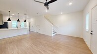 Located at 101 Fox Grape Loop in Weaverville, NC, this two-story home offers a thoughtfully designed layout across two well-proportioned floors. The main level features an open-concept kitchen and living area finished with light luxury vinyl plank flooring throughout. The kitchen is equipped with stainless steel appliances, including a French door refrigerator, electric range, and microwave, complemented by two-tone cabinetry in sage and soft blue, a white quartz countertop, and a undermount sink. The living area is bright and airy, featuring recessed lighting, a ceiling fan, and flanking windows that allow natural light to fill the space. A half bathroom is conveniently located on the main floor. Upstairs, the primary bedroom is a generously sized retreat with plush carpet, a ceiling fan, and a walk-in closet with wire shelving. The primary en-suite bathroom features a glass-enclosed walk-in shower with matte black fixtures and a vanity with undermount sink. A second well-sized bedroom also features carpet flooring, a ceiling fan, and natural light from a window. An additional full bathroom and a second carpeted walk-in closet round out the upper level. Throughout the home, a consistent palette of crisp white walls and matte black hardware lends a clean, contemporary aesthetic.