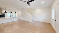 Located at 101 Fox Grape Loop in Weaverville, NC, this two-story home offers a thoughtfully designed layout across two well-proportioned floors. The main level features an open-concept kitchen and living area finished with light luxury vinyl plank flooring throughout. The kitchen is equipped with stainless steel appliances, including a French door refrigerator, electric range, and microwave, complemented by two-tone cabinetry in sage and soft blue, a white quartz countertop, and a undermount sink. The living area is bright and airy, featuring recessed lighting, a ceiling fan, and flanking windows that allow natural light to fill the space. A half bathroom is conveniently located on the main floor. Upstairs, the primary bedroom is a generously sized retreat with plush carpet, a ceiling fan, and a walk-in closet with wire shelving. The primary en-suite bathroom features a glass-enclosed walk-in shower with matte black fixtures and a vanity with undermount sink. A second well-sized bedroom also features carpet flooring, a ceiling fan, and natural light from a window. An additional full bathroom and a second carpeted walk-in closet round out the upper level. Throughout the home, a consistent palette of crisp white walls and matte black hardware lends a clean, contemporary aesthetic.
