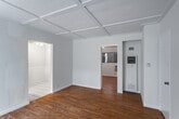 Located at 726 N Alfred St in the heart of West Hollywood, this single-floor residence offers a well-organized layout with a clean, neutral aesthetic throughout. The living areas are anchored by warm hardwood flooring and distinctive coffered ceilings with a beadboard finish, lending a subtle architectural character to the space. Natural light filters in through windows dressed with vertical blinds, contributing to a bright and open atmosphere.

The galley-style kitchen is efficiently designed, featuring white cabinetry with modern hardware, classic white subway tile backsplash, light stone countertops, a double stainless steel sink with a brass faucet, a gas range, and a full-size refrigerator. White tile flooring and a window with decorative ironwork complete the kitchen's clean, functional look.

The bedrooms are generously proportioned, each offering hardwood floors, the signature coffered ceilings, and abundant closet space — including rooms with dual open closets. Wall-mounted air conditioning units provide climate control. The bathroom is well-appointed with a tub and shower combination enclosed by sliding glass doors, warm wood cabinetry for storage, and classic white fixtures. The overall ambiance of the space is bright, practical, and move-in ready.