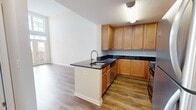 This contemporary 1000 square foot apartment in Herndon, VA, is a well-designed living space spread across two floors. The ground floor, spanning 650 square feet, hosts an open-concept kitchen and living room. The kitchen boasts wooden cabinetry, stainless steel appliances, and black granite countertops, creating a sleek and functional cooking area. Hardwood flooring extends throughout the main living spaces, adding warmth and elegance.

The upper floor, comprising 350 square feet, features a spacious 180 square foot bedroom with plush carpeting and large windows that flood the room with natural light. The bathroom showcases a modern vanity with ample storage and a large mirror. A closet provides additional storage space.

Notable features include high ceilings in the living area, complemented by tall windows and glass doors that lead to a balcony, enhancing the sense of space and light. The staircase connecting the two floors adds architectural interest to the interior. The neutral color palette throughout allows for versatile decorating options, while the overall design emphasizes a clean, minimalist aesthetic. This apartment efficiently utilizes its space, offering a comfortable and stylish urban living experience.