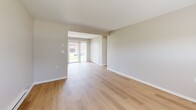 Located at 2372 Beckwith Dr, Unit B, in Indianapolis, Indiana, this one-bedroom, one-bathroom unit offers a well-organized single-floor layout with consistent, modern finishes throughout. Light wood-style flooring runs seamlessly across every room, creating a cohesive and clean aesthetic complemented by neutral warm-gray walls and crisp white trim.

The combined kitchen and living area forms the heart of the unit. The kitchen is outfitted with white shaker-style cabinetry, a subway tile backsplash, stainless steel appliances including a refrigerator, electric range, and microwave, plus a single-basin sink. A window above the dining area and a glass door flood the space with natural light and provide outdoor views.

The open living room connects directly to the rest of the unit and benefits from additional natural light through a window with blinds. Baseboard heating runs along the perimeter, ensuring comfort year-round.

The bedroom is a well-proportioned private retreat featuring a large window with outdoor views, a wall-mounted HVAC unit, baseboard heating, and a spacious double-door closet for ample storage.

The bathroom is clean and functional, featuring a bathtub with a shower curtain rod, a toilet, and the same light wood-style flooring found throughout the unit.