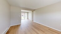 Located at 2372 Beckwith Dr, Unit B, in Indianapolis, Indiana, this one-bedroom, one-bathroom unit offers a well-organized single-floor layout with consistent, modern finishes throughout. Light wood-style flooring runs seamlessly across every room, creating a cohesive and clean aesthetic complemented by neutral warm-gray walls and crisp white trim.

The combined kitchen and living area forms the heart of the unit. The kitchen is outfitted with white shaker-style cabinetry, a subway tile backsplash, stainless steel appliances including a refrigerator, electric range, and microwave, plus a single-basin sink. A window above the dining area and a glass door flood the space with natural light and provide outdoor views.

The open living room connects directly to the rest of the unit and benefits from additional natural light through a window with blinds. Baseboard heating runs along the perimeter, ensuring comfort year-round.

The bedroom is a well-proportioned private retreat featuring a large window with outdoor views, a wall-mounted HVAC unit, baseboard heating, and a spacious double-door closet for ample storage.

The bathroom is clean and functional, featuring a bathtub with a shower curtain rod, a toilet, and the same light wood-style flooring found throughout the unit.