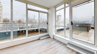 Located at 50 Spadina Rd in Toronto's prestigious Annex neighbourhood, this two-storey, 2-bedroom, 2-bathroom residence offers generous living space spread across two well-defined floors. The main level hosts an open-concept living and dining area bathed in natural light through expansive floor-to-ceiling windows and sliding glass doors that lead to balconies overlooking the city skyline. Light hardwood-style flooring runs throughout, complementing the clean white walls and bright, airy atmosphere. The modern kitchen features a large island with sleek stone countertops, an undermount sink, white shaker-style cabinetry, subway tile backsplash, and stainless steel appliances, with direct access to an outdoor balcony. Two full bathrooms are finished with light tile flooring and white vanities. The spacious primary bedroom includes an ensuite bathroom and city-facing windows, while the second bedroom is well-proportioned with natural light. Three balconies provide multiple outdoor spaces with views of Toronto's skyline, including a notable rooftop terrace with panoramic city views. Additional features include in-suite laundry, multiple closets offering ample storage, and two staircases connecting the floors.