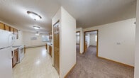 Located at 307 E Seventh St in Monticello, Minnesota, this single-floor, 3-bedroom, 1-bathroom home offers a practical and comfortable layout. The open galley-style kitchen is well-equipped with warm oak cabinetry lining both walls, white appliances including a stove, microwave, and refrigerator, light countertops, and easy-to-clean tile flooring. The kitchen flows seamlessly into the dining and living area, which features a ceiling fan, a fireplace, baseboard heating, and a window that brings in natural light. Sliding glass doors in the spacious living room open to an outdoor area, enhancing the sense of openness. The three bedrooms are carpeted for comfort, each featuring bifold closet doors with built-in shelving and hanging rods for organized storage. The generously sized primary bedroom offers ample space. The full bathroom is finished with tile flooring, an oak vanity with a large mirror, a lighted vanity fixture, and a tub-shower combination. Textured ceilings are found throughout much of the home, and warm oak wood trim and doors provide a consistent, cohesive aesthetic. Baseboard heating is present throughout, ensuring warmth during Minnesota winters.