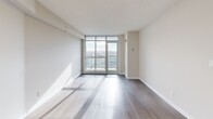 Located at 2 Vena Way in Toronto's Humber Summit neighbourhood, this efficiently designed one-bedroom, one-bathroom unit offers a clean, modern aesthetic throughout. The open-concept living and kitchen area is anchored by a striking peninsula with a marble-look quartz countertop and an integrated sink, complemented by dark walnut-toned cabinetry, a white subway tile backsplash, and stainless steel appliances. Light-toned laminate hardwood flooring flows seamlessly through the main living space, enhancing the bright and airy atmosphere. Floor-to-ceiling windows and a sliding balcony door flood the living area with natural light while framing sweeping views of the Toronto skyline and surrounding landscape. The bedroom is a well-proportioned, sun-filled room featuring large windows with similarly impressive views, warm hardwood-style flooring, and a built-in sliding-door closet offering practical storage. The four-piece bathroom is finished with warm beige tile flooring, a dark wood vanity with a white countertop, and a full soaker tub with white subway tile surround. The overall palette of soft neutrals, contemporary finishes, and abundant natural light creates a cohesive and inviting living environment.