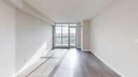 Located at 2 Vena Way in Toronto's Humber Summit neighbourhood, this efficiently designed one-bedroom, one-bathroom unit offers a clean, modern aesthetic throughout. The open-concept living and kitchen area is anchored by a striking peninsula with a marble-look quartz countertop and an integrated sink, complemented by dark walnut-toned cabinetry, a white subway tile backsplash, and stainless steel appliances. Light-toned laminate hardwood flooring flows seamlessly through the main living space, enhancing the bright and airy atmosphere. Floor-to-ceiling windows and a sliding balcony door flood the living area with natural light while framing sweeping views of the Toronto skyline and surrounding landscape. The bedroom is a well-proportioned, sun-filled room featuring large windows with similarly impressive views, warm hardwood-style flooring, and a built-in sliding-door closet offering practical storage. The four-piece bathroom is finished with warm beige tile flooring, a dark wood vanity with a white countertop, and a full soaker tub with white subway tile surround. The overall palette of soft neutrals, contemporary finishes, and abundant natural light creates a cohesive and inviting living environment.