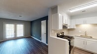 Located at 1915 Morningside Dr in Burlington, North Carolina, this single-floor unit offers a well-organized layout with clean, updated finishes throughout. The living area is a standout feature, presenting dark hardwood-style flooring, neutral gray walls accented by a bold teal-blue feature wall, and a textured ceiling that adds subtle character. A window allows natural light to filter into the space, enhancing its open feel.

The kitchen is thoughtfully designed with white shaker-style cabinetry extending to the ceiling, light stone-toned countertops, and a classic subway tile backsplash. Stainless steel appliances—including a refrigerator and electric range—complement the bright, functional space, which is illuminated by overhead flush lighting and features light hardwood-style flooring.

A separate bedroom offers plush carpeting, a ceiling fan with integrated lighting, and a window that brings in additional natural light. The bathroom includes a clean, all-white tub and shower surround, maintaining a simple and practical aesthetic.

Additional living or flex spaces are accessible via interior doors, providing versatile options for use. Throughout the unit, consistent white trim and panel-style doors contribute to a cohesive, move-in-ready presentation.