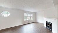 Located at 401 Elkwood Drive in Coraopolis, PA, this three-bedroom, three-bathroom home spans three floors, offering a thoughtfully organized layout with dedicated spaces for living, working, and storage. The ground floor houses an attached garage with an automatic opener and a utility room, providing practical functionality at the base of the home. The main living floor serves as the heart of the residence, featuring a bright, open living room with rich hardwood-style flooring, crown molding, and a textured ceiling. Large windows, including a distinctive circular porthole window, invite abundant natural light and neighborhood views. The combined dining room and kitchen is well-appointed with dark cabinetry, granite-look countertops, stainless steel appliances, and warm wood-tone flooring. A den on this level adds flexible space for a home office or sitting room. The upper floor contains all three bedrooms, each finished with plush carpet and natural light from generous windows. The spacious primary bedroom is complemented by ample closet space. Three full bathrooms throughout the home each feature tub-shower combinations and clean, modern finishes with wood-look flooring. Carpeted staircases with dark handrails connect all three levels, completing this well-structured and comfortable home.