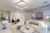 Located at 624 NE Second St in Dania Beach, FL, this thoughtfully designed 2-bedroom, 2-bathroom residence offers a seamless single-floor layout with modern finishes throughout. The open-concept living and dining area is anchored by a striking geometric LED ceiling fixture and complemented by recessed lighting, light-toned tile flooring, and a neutral color palette that creates a bright, airy atmosphere. The living room accommodates generous seating and flows effortlessly into the dining space, making it ideal for both relaxing and entertaining. The kitchen features warm taupe cabinetry, granite countertops, stainless steel appliances, and a peninsula with bar seating that connects it to the main living area. The primary bedroom is a well-proportioned retreat, highlighted by a bold circular pendant light, natural light from a window with outdoor views, and a patterned area rug adding texture and warmth. A spacious walk-in closet with wire shelving provides ample storage. The bathrooms are finished with large-format tile, glass-enclosed showers, and granite vanity tops. A second living area or flex space features track lighting, natural light, and a clean, minimalist aesthetic. Two dedicated closets complete this well-organized and stylish residence.