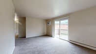 Located at 933 Wilmington Ave in Dayton, Ohio, this single-floor residence offers three bedrooms, two bathrooms, a kitchen, and two closets in a practical and functional layout. The living room is a generous, light-filled space featuring neutral carpet, a wall-mounted air conditioning unit, baseboard heating, and a sliding glass door that opens onto a private wooden balcony with outdoor views — bringing in abundant natural light and a connection to the outdoors. The galley-style kitchen is well-appointed with dark espresso cabinetry, granite-style countertops, white appliances including an electric range and refrigerator, and tile flooring, with direct access to adjacent areas of the home. The bedrooms are carpeted and finished in neutral tones; the spacious primary bedroom offers a wall AC unit and a window, while secondary bedrooms include louvered bifold closet doors with built-in hanging rods for organized storage. The two bathrooms feature tile flooring, vanities with mirrored medicine cabinets, and classic white fixtures; one includes a tiled shower-tub combination. Throughout, the home maintains a clean, neutral aesthetic well-suited for comfortable everyday living.