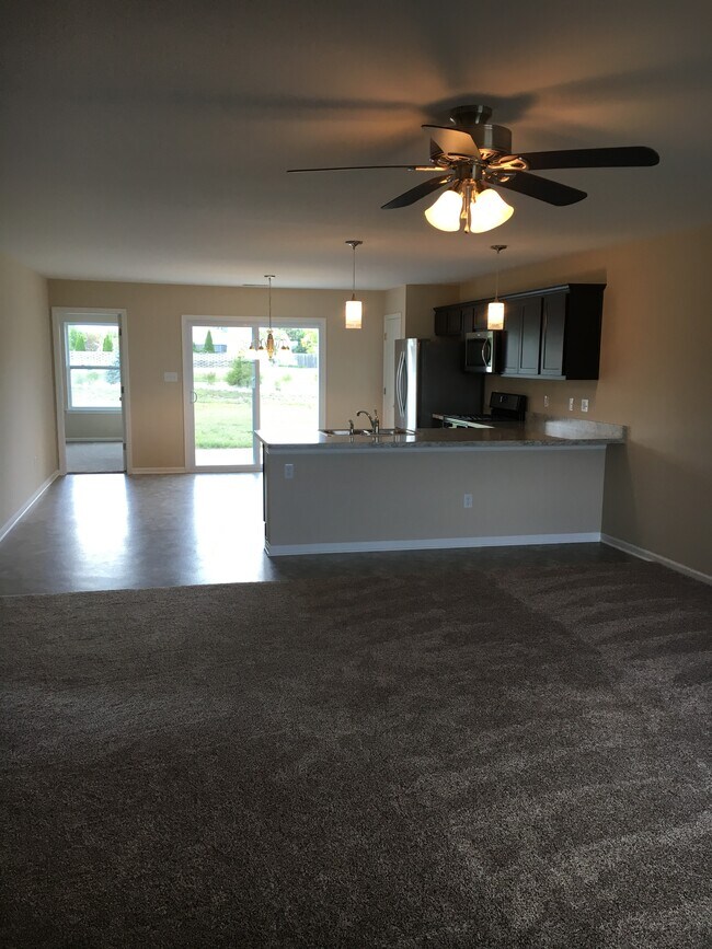 Vista desde la puerta principal hacia la sala de estar, la cocina y el patio exterior - 8590 Jackson St