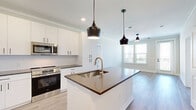 Located at 201 Hills Rd in Panama City Beach, FL, this well-appointed single-story home offers 2 bedrooms, 3 bathrooms, and a thoughtfully designed layout that maximizes comfort and functionality. Light-toned luxury vinyl plank flooring runs throughout, complementing the bright, neutral palette that gives every room a clean, contemporary feel.

The heart of the home is an open-concept kitchen and living area. The kitchen stands out with crisp white shaker cabinetry, dark quartz countertops, a central island with an undermount sink and dishwasher, and a full suite of stainless steel GE appliances. Stylish matte black pendant lights hang above the island, adding a modern contrast to the white finishes.

The spacious primary bedroom features crown molding and a ceiling fan, with natural light filtering through window blinds. It connects to a generously sized walk-in closet with wire shelving systems. The bathrooms maintain the same refined aesthetic, with white cabinetry, dark countertops, matte black hardware, and glass-enclosed showers.

The second bedroom is bright and comfortable, also adorned with crown molding. A dedicated laundry room houses a full-size GE washer and dryer with overhead wire shelving for added storage. Two closets provide ample organization throughout the home, making this residence as practical as it is visually appealing.
