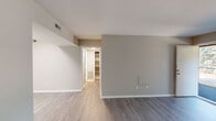 Located at 2424 Gazebo Dr in Morrisville, North Carolina, this single-floor unit offers a clean, functional layout designed for comfortable everyday living. The open living area is finished with durable wood-look luxury vinyl plank flooring and neutral gray-toned walls that create a bright, welcoming atmosphere. A large window allows natural light to pour in, offering views of the surrounding greenery outside. The space flows into a well-lit secondary area, ideal for dining or additional living use.

The kitchen is equipped with stainless steel appliances, including an electric range and an over-the-range microwave, complemented by crisp white cabinetry and light countertops that give the space a modern, polished feel. The bedrooms are carpeted for added comfort and feature ample wall space and windows that bring in natural light. A dedicated closet provides organized built-in shelving for storage.

The bathroom includes a full tub and shower combination with clean white tile surround and chrome fixtures. A conveniently located utility closet houses an in-unit washer and HVAC system, adding practical functionality to the layout. Throughout the unit, consistent white trim, neutral paint tones, and thoughtful finishes contribute to a cohesive and move-in-ready living environment.