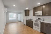 Located at 18730 Miner Ln in Morgan Hill, CA, this single-story, 2-bedroom, 1-bathroom home offers a clean and modern layout designed for comfortable everyday living. Light wood-style flooring flows throughout the space, complementing the bright white walls and creating a cohesive, airy aesthetic.

The living room provides a welcoming common area, while the kitchen features white appliances and warm wood-toned cabinetry. A dedicated utility room adds practical storage and laundry functionality. The hallway connects the main living areas to the private bedrooms efficiently.

Both bedrooms are well-proportioned, each featuring large windows with horizontal blinds that allow generous natural light. The primary bedroom includes a wall-mounted mini-split HVAC unit for individual climate control. Sliding closet doors in the bedrooms reveal built-in shelving and hanging rods, maximizing storage.

The bathroom is neatly appointed with light wood-toned cabinetry, a single vanity with a large mirror, and wood-style flooring consistent with the rest of the home. A dedicated balcony extends the living space outdoors, offering additional fresh air and outdoor access.

A smart thermostat panel is visible in the hallway, reflecting thoughtful modern conveniences throughout. The overall ambiance is minimal, bright, and move-in ready.