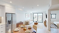 Located at 1112 Locust Ave in Long Beach, CA, this modern single-floor residence showcases a clean, contemporary design throughout. The open-concept living and dining area is anchored by light hardwood flooring, recessed lighting, and crisp white walls that create a bright, airy atmosphere. A large floor-to-ceiling sliding glass door floods the living space with natural light while offering open views of the surrounding cityscape, seamlessly connecting the interior to the outdoors.

The kitchen is efficiently designed with flat-front white cabinetry extending to the ceiling, light quartz countertops, a neutral tile backsplash, stainless steel appliances including a gas range and built-in microwave, and matte black fixtures that add a refined contrast to the otherwise bright palette.

The bedrooms are tranquil and well-proportioned, each featuring recessed lighting, light wood flooring, and windows with city views. The restful, neutral color scheme carries throughout, lending a cohesive and calming quality to each room.

The bathroom continues the home's modern aesthetic with a large framed mirror, a sleek white vanity with integrated drawers, matte black hardware, and terrazzo-style flooring that adds a subtle textural detail. Overall, this residence presents a polished, contemporary living environment in the heart of Long Beach.