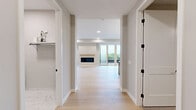 Located at 4909 France Ave S in Minneapolis, this thoughtfully designed single-floor home offers three bedrooms, five bathrooms, and a generous, well-appointed layout. Light hardwood flooring flows through the open-concept kitchen and living areas, anchored by a striking chef's kitchen featuring light wood cabinetry, a bold navy-blue island with a waterfall countertop, stainless steel professional-grade range, and globe pendant lighting with brass accents. The spacious living room is highlighted by a sleek linear fireplace with a natural wood mantle and sliding glass door access to an outdoor space, allowing natural light to fill the room. The generously sized primary bedroom includes a tray ceiling, a ceiling fan, and large windows with outdoor views, alongside a well-organized walk-in closet with full built-in shelving and hanging systems. The primary bathroom is a standout, showcasing marble-look tile throughout, a freestanding soaking tub, a glass-enclosed shower, and elegant brass fixtures. Additional bathrooms continue the marble tile aesthetic with tub-shower combinations. Secondary bedrooms feature soft carpet, tray ceilings, and ample closet access. A dedicated laundry room includes side-by-side Whirlpool washer and dryer, overhead cabinetry with brass hardware, and a folding counter.
