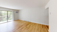 Located in Atlantic Highlands, NJ, this well-appointed 2-bedroom, 2-bathroom residence offers a clean, modern aesthetic across a single floor. The layout is thoughtfully organized, connecting a spacious living room, kitchen, two bedrooms, two bathrooms, a utility room, and hallways in a cohesive flow.

The kitchen is a standout feature, outfitted with crisp white shaker cabinetry, gleaming white quartz countertops, and a full suite of stainless steel appliances including a range, over-the-range microwave, refrigerator, and dishwasher. A pass-through window connects the kitchen to the adjacent living area, enhancing the open feel.

The living room and both bedrooms feature warm natural hardwood flooring and neutral white walls, creating a bright and inviting atmosphere. Windows in each bedroom frame views of surrounding greenery, bringing natural light into every corner. The primary bedroom offers a generous footprint with ample wall space.

The two bathrooms are finished in a clean, neutral palette. The full bath includes a tiled tub-shower combo, a vanity with white countertop, and marble-style tile flooring. The second bathroom features a compact vanity with a medicine cabinet above, ideal as a half or guest bath.

Overall, the space presents a fresh, move-in-ready interior with consistent modern finishes throughout.