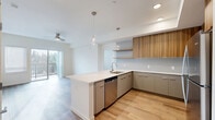 Located at 18807 8th Ave NE in Shoreline, WA, this well-designed one-bedroom, two-bathroom residence offers a thoughtful layout across a single floor. The open-concept kitchen and living area serves as the heart of the home, anchored by a generous island with a striking white quartz waterfall countertop and an undermount sink. The kitchen features warm wood-grain upper cabinetry, sage-toned lower cabinets, a soft grey subway tile backsplash, floating wood shelves, and a full suite of stainless steel appliances, including a refrigerator, range, microwave, and dishwasher. Glass globe pendant lights add an elegant finishing touch. Light hardwood flooring flows seamlessly throughout the entire residence, complementing the bright, neutral color palette. The living area extends toward a sliding glass door that opens to a private balcony overlooking lush tree views, with a ceiling fan adding comfort to the space. The bedroom is comfortably sized, filled with natural light from a large window, and includes a closet. Both bathrooms are finished with grey vanities, white countertops, wood-look flooring, and brushed nickel grab bars. The clean, modern aesthetic and well-appointed finishes make this Shoreline residence a refined and functional place to call home.