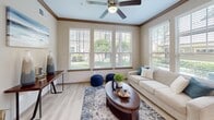 Located at 2500 S Millbend Dr in Spring, TX, this single-floor, 3-bedroom, 2-bathroom residence offers a well-planned layout that maximizes functionality and comfort. The open-concept living, dining, and kitchen area forms the heart of the home, with light wood-style flooring, crown molding, and large windows that invite abundant natural light and outdoor views. The living room features a ceiling fan and multiple windows overlooking greenery, creating a bright and airy atmosphere. The kitchen is equipped with rich dark cabinetry, a mosaic tile backsplash, black appliances, and a granite-topped island with a built-in sink — ideal for both cooking and casual interaction. The dining area sits adjacent, accented by a round wall mirror and pendant lighting overhead. The primary bedroom offers a ceiling fan, natural light through slatted blinds, and a built-in desk nook, while the additional bedrooms are well-proportioned with ample closet access. Both bathrooms feature soaking tubs with full marble-style tile surrounds. A dedicated laundry area and four closets provide excellent storage throughout. The private patio rounds out this thoughtfully appointed residence.