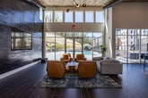 Located at 230 Flagship Way in Knoxville, Tennessee, this single-story amenity center is thoughtfully designed to offer residents a comprehensive suite of communal spaces. The welcoming lobby entrance features wood-look tile flooring, crisp white walls, and a seating area with modern lounge chairs, setting the tone for the contemporary aesthetic found throughout.

The dramatic main lounge commands attention with soaring ceilings clad in warm wood paneling, a full-height dark brick accent wall with a mounted flat-screen TV, and an expansive floor-to-ceiling glass wall that floods the space with natural light and provides direct views of the outdoor pool area. Comfortable seating arrangements make this an ideal gathering spot.

The clubroom kitchen is outfitted with light wood cabinetry, white subway tile backsplash, a bold dark granite island, and a teal accent wall that extends to the ceiling, creating a striking visual centerpiece.

Two dedicated conference rooms offer built-in technology, stylish pendant lighting, and ample natural light through large windows, making them well-suited for focused work or meetings. Private study pods with warm wood-paneled walls provide quiet individual workspaces.

The fully equipped fitness center includes a multi-functional strength rack, free weights, punching bag, cardio machines, and floor-to-ceiling mirrors, anchored by a bold teal accent wall and durable rubber flooring.