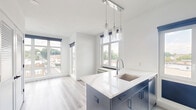 Located at 106 Washington Ave in Belleville, NJ, this thoughtfully designed one-bedroom, one-bathroom unit offers a clean, contemporary living experience across a single well-organized floor. Light wood-look flooring runs throughout the main living areas and bedroom, lending warmth and visual continuity to the space.

The kitchen is a standout feature, finished with sleek navy-blue cabinetry, white quartz countertops, a stainless steel sink, and modern appliances including a dishwasher and range. A large window with blue roller shades frames an open rooftop view of the Belleville skyline, flooding the kitchen with natural light.

The spacious bedroom continues the light-filled theme, featuring a tall window with the same blue roller shades and an in-unit PTAC heating and cooling unit for year-round climate control. The views of the surrounding neighborhood add a pleasant urban backdrop.

The bathroom is finished in a modern, contrasting style with dark slate-toned floor tiles, charcoal-colored cabinetry, a floating white vanity with an undermount sink, a frameless mirror, and clean white fixtures.

A bright hallway connects all rooms efficiently, with white panel doors and crisp white walls reinforcing the unit's fresh, minimalist aesthetic. A dedicated closet provides practical storage. Overall, the space exudes a modern, move-in-ready character with quality finishes throughout.