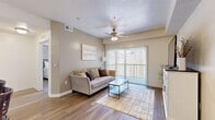 Located on W Seasons View Ct in Lehi, Utah, this well-designed one-bedroom, one-bathroom residence offers a smart and functional layout across a single floor. The open-concept living and kitchen area serves as the heart of the home, where wood-look flooring, neutral tones, and a ceiling fan with light fixture create a comfortable, welcoming atmosphere. A sliding glass door fills the living room with natural light and provides direct access to an outdoor balcony, offering views of the surrounding area. The kitchen is equipped with rich dark cabinetry, stainless steel refrigerator, gas range, and a peninsula with a built-in sink and bar seating, illuminated by pendant lighting overhead — ideal for both cooking and casual dining. The bedroom features plush carpeting, a natural light-filled window, and access to a spacious walk-in closet with built-in shelving. The full bathroom includes dark wood cabinetry, a white countertop vanity, tile-style flooring, and a shower-tub combination. A dedicated laundry area with a full-size washer and dryer adds significant convenience. Throughout, the design balances practicality with clean, modern aesthetics suited for comfortable everyday living.
