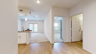 This well-appointed single-floor residence offers a clean, modern design characterized by an open-concept layout and an abundance of natural light. The kitchen is a functional highlight, featuring crisp white shaker cabinetry, granite countertops, a subway tile backsplash, and a full suite of stainless steel appliances including a range, microwave, and dishwasher. Pendant lighting above the breakfast bar adds a refined touch, while wood-look flooring ties the kitchen and main living areas together seamlessly. The spacious living area transitions naturally from the kitchen and dining space, with plush carpeting underfoot and access to a private outdoor area through glass-paned doors. The bedrooms are generously sized, each finished with soft carpet, multiple windows with blinds for natural light and privacy, and ceiling fans for added comfort. The bathrooms are tastefully designed, with white cabinetry, granite-topped vanities, large mirrors, and wood-look flooring. One bathroom includes a glass-enclosed walk-in shower with clean white tile surround. Throughout the residence, recessed lighting, neutral wall tones, and consistent finishes create a cohesive and inviting atmosphere well-suited for comfortable everyday living.