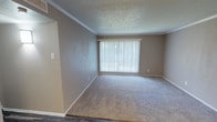 Located at 602 W Pioneer Pkwy in Grand Prairie, Texas, this single-floor unit offers a practical and updated living space with a clean, neutral aesthetic throughout. The open entryway transitions between two distinct flooring surfaces — durable wood-look vinyl planking in the main traffic areas and plush carpet in the living and bedroom spaces — creating a clear and functional layout.

The living area is generously proportioned, featuring crown molding, a textured ceiling, and a large window fitted with vertical blinds that allows natural light to fill the room. Adjacent to the living space, the kitchen is well-appointed with white cabinetry, light quartz-style countertops, a mosaic tile backsplash, a double stainless steel sink, and black appliances including a refrigerator and range. The wood-look flooring continues throughout the kitchen, adding visual continuity.

The bedrooms are carpeted and each includes a ceiling fan with light fixture and a window with blinds for natural light and privacy. The bathrooms feature wood-look vinyl flooring; one includes a tiled tub-and-shower surround with warm earth-tone tiles, while the second offers a tub-shower combo with white fixtures. Both bathrooms include white vanity cabinetry. The overall space presents a well-maintained, move-in-ready interior with consistent finishes throughout.