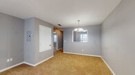 This single-story home in Tupelo, Mississippi features a thoughtfully arranged floor plan with two bedrooms and two bathrooms. The interior is finished with cool gray walls and warm tan carpeting throughout the living and sleeping areas, creating a neutral and welcoming atmosphere.

The dining area is highlighted by an elegant chandelier and a window that brings in natural light, while a pass-through opening connects it to adjacent spaces for an open feel. The living room is generously sized, featuring a ceiling fan with light kit and clean, simple lines throughout.

The kitchen is well-appointed with white cabinetry, light countertops, a stainless steel sink, and black appliances including an electric range and dishwasher. Light wood-look vinyl flooring adds a clean, contemporary touch to this functional cooking space.

Both bedrooms are comfortably scaled, each equipped with a ceiling fan and carpeted floors. Natural light filters through window blinds, offering views of the surrounding greenery. The two bathrooms include a vanity with white cabinetry and a large mirror, along with a tub and shower combination, providing functional and straightforward design. This home offers a well-organized, move-in-ready layout suited for comfortable everyday living.