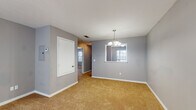 This single-story home in Tupelo, Mississippi features a thoughtfully arranged floor plan with two bedrooms and two bathrooms. The interior is finished with cool gray walls and warm tan carpeting throughout the living and sleeping areas, creating a neutral and welcoming atmosphere.

The dining area is highlighted by an elegant chandelier and a window that brings in natural light, while a pass-through opening connects it to adjacent spaces for an open feel. The living room is generously sized, featuring a ceiling fan with light kit and clean, simple lines throughout.

The kitchen is well-appointed with white cabinetry, light countertops, a stainless steel sink, and black appliances including an electric range and dishwasher. Light wood-look vinyl flooring adds a clean, contemporary touch to this functional cooking space.

Both bedrooms are comfortably scaled, each equipped with a ceiling fan and carpeted floors. Natural light filters through window blinds, offering views of the surrounding greenery. The two bathrooms include a vanity with white cabinetry and a large mirror, along with a tub and shower combination, providing functional and straightforward design. This home offers a well-organized, move-in-ready layout suited for comfortable everyday living.