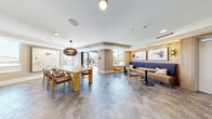 Located on West Sunset Boulevard in the heart of Los Angeles, this thoughtfully designed amenity floor offers a generous and versatile common space across a single level. The entry corridor sets a polished tone with large-format tile flooring, curated wall art, a wood bench, and a striking circular pendant light overhead. Elevator access and glass doors leading to the outdoor pool area are conveniently situated along this hall.

The social lounge is a standout feature, showcasing distinctive hexagonal tile flooring, abundant natural light from floor-to-ceiling windows, and a mix of casual seating arrangements including a tufted navy banquette, dining tables, and lounge chairs. A sleek bar area anchors one end of the space, featuring a dramatic dark-tile backsplash, stone countertops, and modern teardrop pendant lighting over a substantial island with bar seating.

A cozy living room area offers warm wood-paneled walls, a large flat-screen television, and comfortable furnishings with views to the surrounding neighborhood. An interior dining nook with hexagonal blue tile floors opens directly onto a sunlit outdoor terrace through full-height sliding glass doors.

The outdoor spaces include a landscaped terrace with built-in concrete and brick seating, as well as a resort-style swimming pool surrounded by lounge chairs, umbrellas, and lush plantings — all framed by the building's contemporary facade.