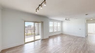 Located in Little Elm, TX, this single-floor, 3-bedroom, 2-bathroom residence offers a well-designed open layout filled with natural light. The living area is highlighted by wood-look tile flooring, a ceiling fan, gold-accented track lighting, and sliding glass doors that open onto a private balcony with outdoor views — an ideal space for relaxing or entertaining.

The kitchen is outfitted with stainless steel appliances, white cabinetry, a grey tile backsplash, dark granite countertops, pendant lighting, and an island with a double sink, flowing seamlessly into the living area.

The generously sized primary bedroom features warm wood-look flooring, a ceiling fan, and direct access to an en-suite bathroom. The bathrooms are well-appointed with dark granite countertops, white cabinetry, mosaic tile accents, and glass-enclosed walk-in showers. Each bedroom benefits from ample natural light through blinds-fitted windows, and the three closets provide substantial storage, including a well-organized walk-in with double hanging rods and shelving. The secondary bedrooms also feature wood-look flooring and ceiling fans. The overall aesthetic is clean, modern, and light-filled throughout.
