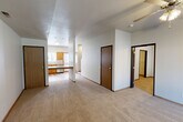 Located at 1103 West Broadway in Columbia, Missouri, this two-story home offers a well-organized layout across two floors, with the main level comprising the larger share of the total living space. The main floor features a spacious living room with plush carpeting and a ceiling fan, flowing into a well-equipped kitchen fitted with warm honey-toned wood cabinetry, stainless steel appliances including a refrigerator, range, microwave, and dishwasher, and light hardwood-style flooring. A built-in countertop peninsula adds a functional workspace between the kitchen and living areas. A second kitchen provides added versatility for multi-use living arrangements. The three bedrooms are carpeted and feature ceiling fans and windows that bring in natural light with views of surrounding greenery. Each bedroom includes closet access, and the home boasts four closets in total for generous storage. The three bathrooms are clean and straightforward, each featuring tub/shower combinations, light tile flooring, and wood-toned vanities. Additional practical spaces include a dedicated laundry room and a utility room. A staircase connects the two floors, and a hallway ties the layout together cohesively. The home's neutral palette and functional design make it a versatile and comfortable residence.